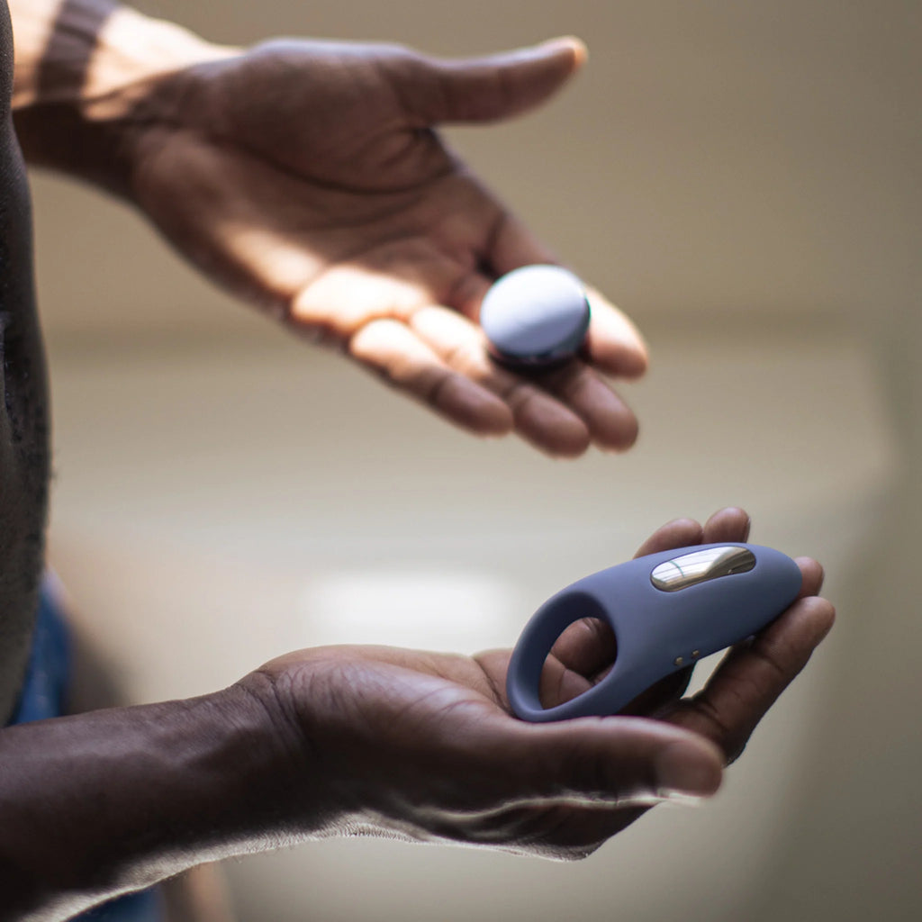 Young Black man holding the silicone cock ring with wireless remote midnight blue